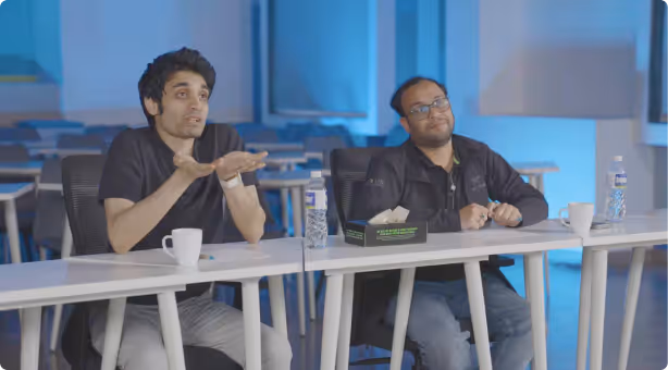 Two students in a mentorship discussion at a classroom table.
