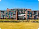 Modern multi-story office building with glass windows and greenery.