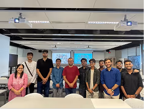 Group of eleven young adults smiling in a modern office space