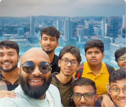 Group of eight young men smiling for a selfie.
