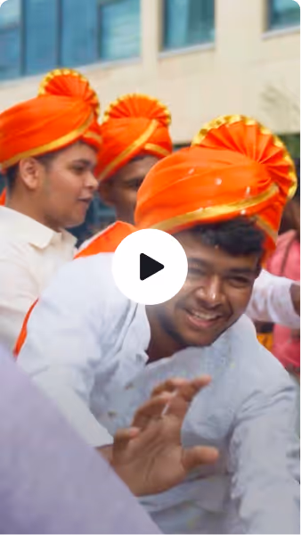 Ganesh Chaturthi, Rishihood University — Smiling men wearing traditional white clothing and bright orange turbans at an outdoor event.
