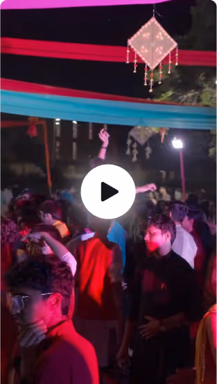 Diwali & Garba Night, Rishihood University — Crowd of people dancing under colourful fabric decorations and hanging lanterns at night.