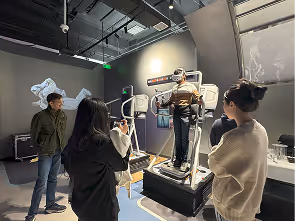 People observing a motion-platform simulator at an indoor tech exhibition