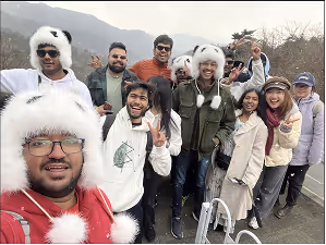 Group of eleven NST students posing for a selfie outdoors in winter clothing