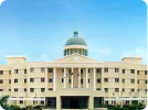 Front view of a large beige institutional building.