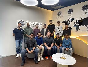 Group of eleven people in an office with a wall map and world clocks